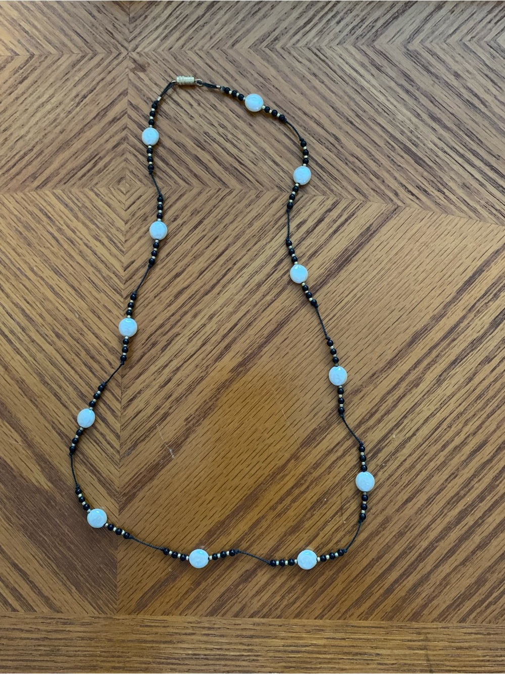 Delicate Black Beaded Necklace with White Disc Accents and Gold Beads